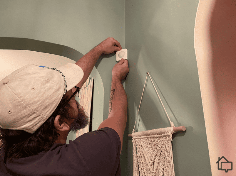 Here’s one of our experts installing the SimpliSafe motion sensors with adhesive backing.